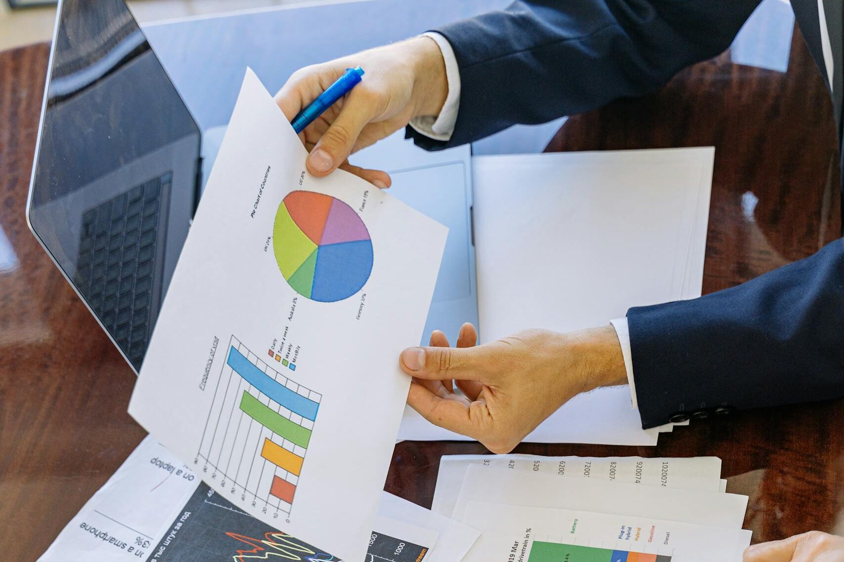 Business professionals analyzing financial charts and graphs during a meeting.